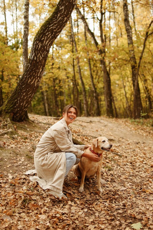 Woman in Brown Coat Touching her Brown Short Coated Dog