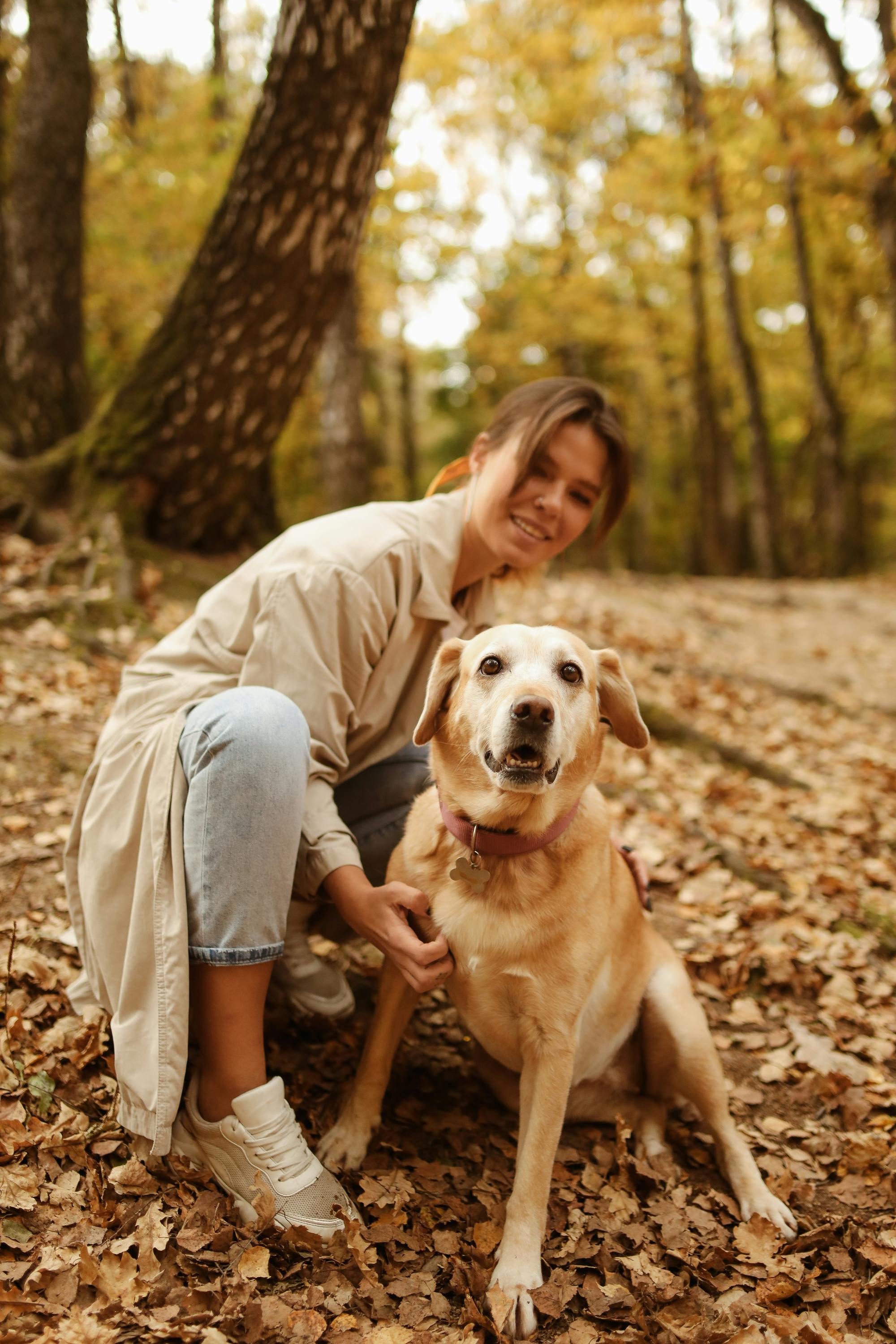 woman sitting next to her brown short coated dog