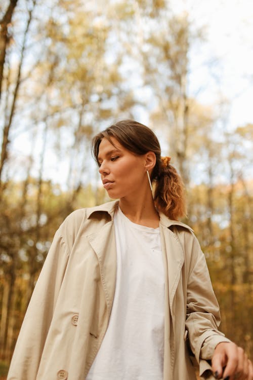 Shallow Focus of Woman in Beige Trench Coat Looking to Her Right