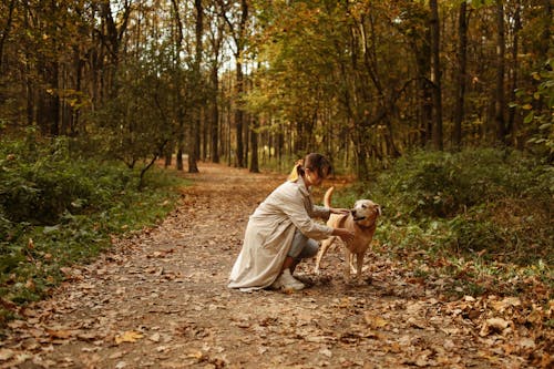 Woman in Beige Trench Coat Touching Her Pet