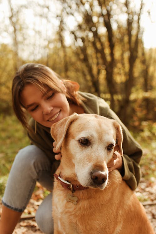 Free Woman Smiling While Looking at Her Labrador Retriever Dog  Stock Photo