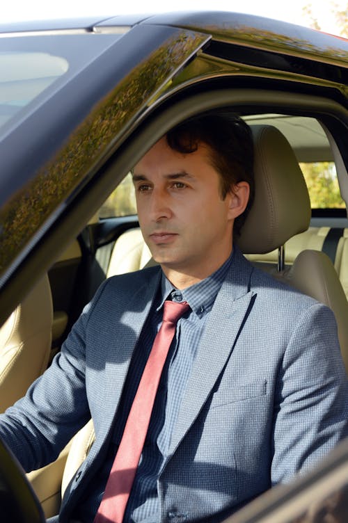 Free Well dressed businessman in car on sunny day Stock Photo