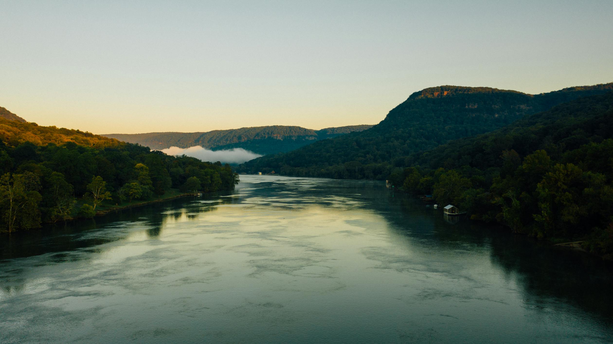 River between ridges under cloudless sky in evening · Free Stock Photo
