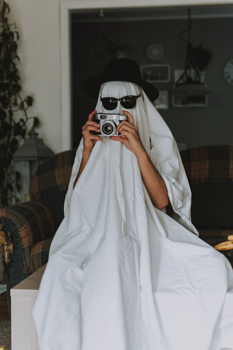 Person With Old Fashioned Camera Wrapped In White Cloth