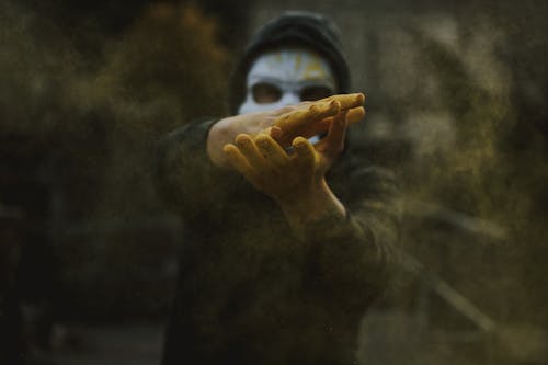 Man in mask clapping hands and spreading powder