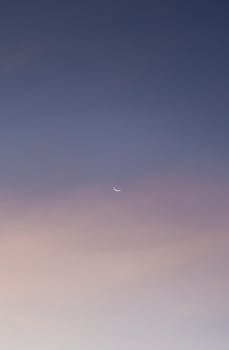 A tranquil twilight sky with a crescent moon, perfect for serene backgrounds.