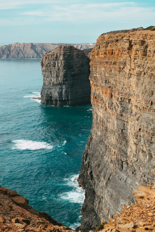 Free Majestic cliffs rise above the blue ocean, capturing nature's rugged beauty in a serene coastal landscape. Stock Photo