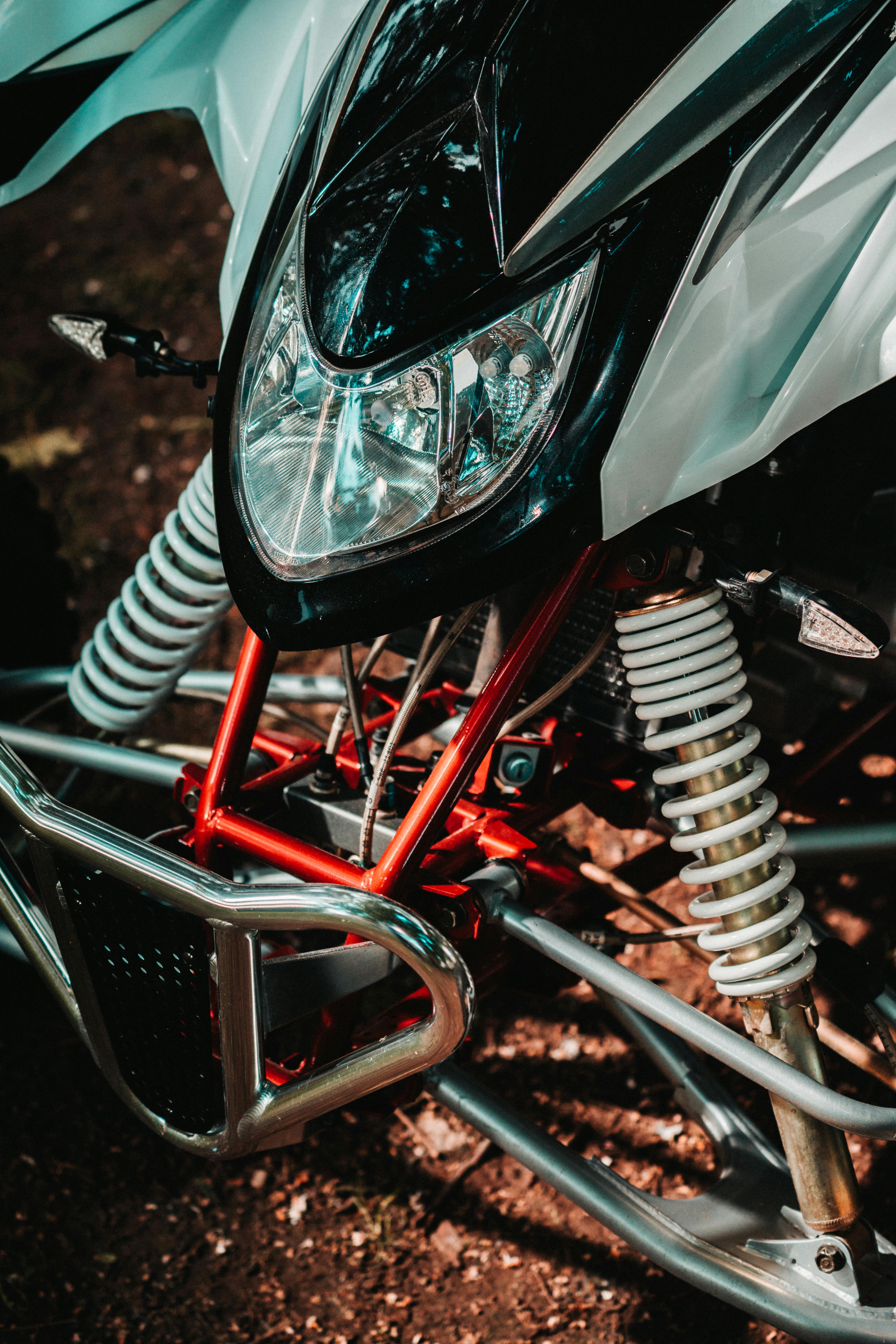 Detailed close-up view of an ATV front end showcasing the headlight and suspension.