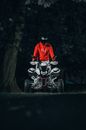 A Person in a Helmet Standing on an ATV