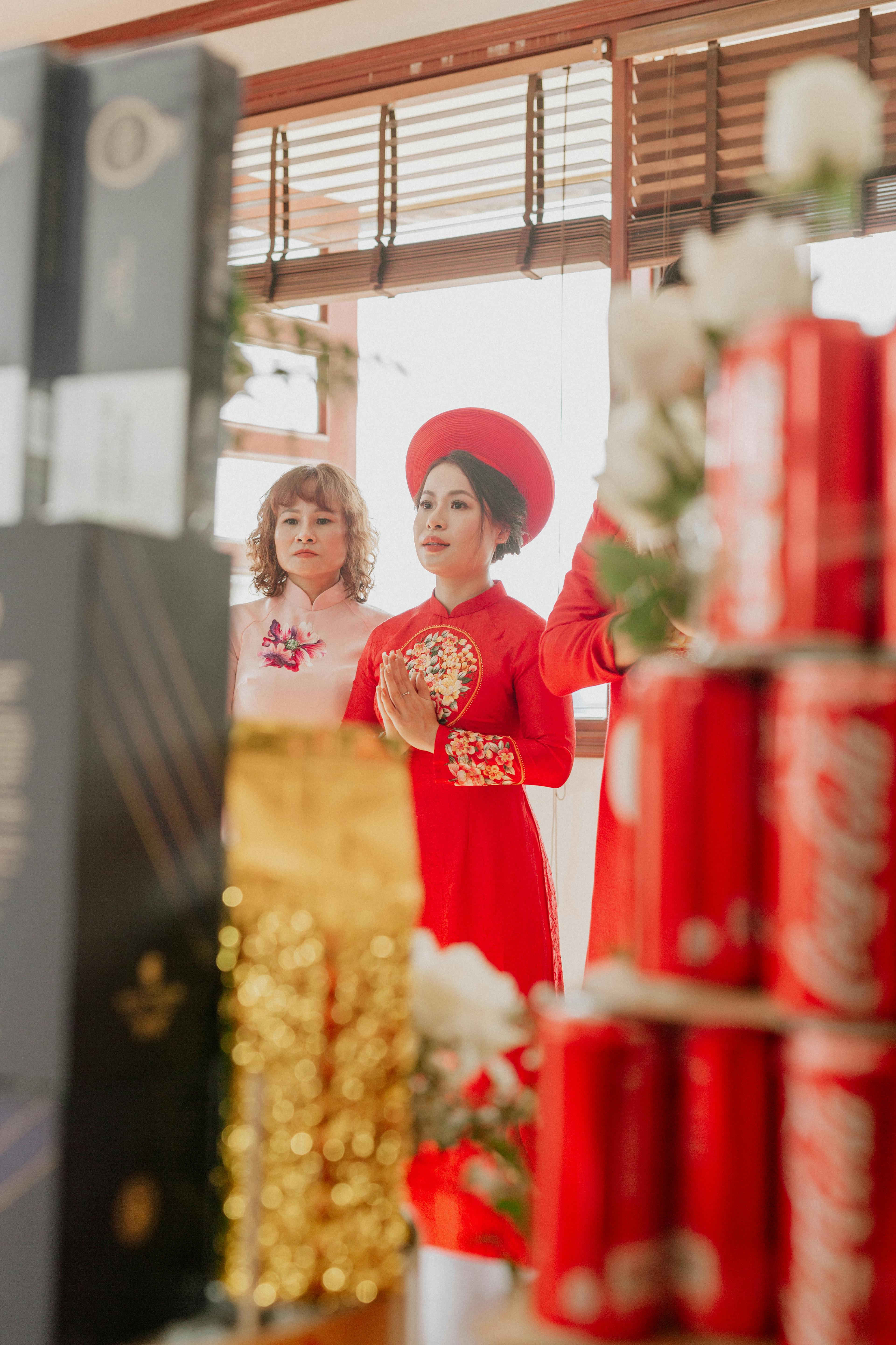 在充满文化元素的室内婚礼上，一位传统的亚洲新娘身着红色服装