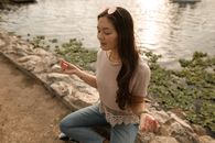 日落时分，女人在湖边冥想，显得宁静而放松