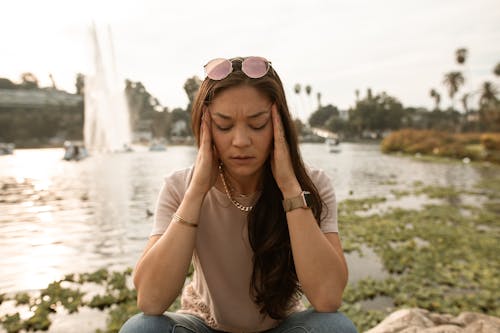 Mulher De Camiseta Cinza E Jeans Azul Com óculos De Sol Rosa Sentada Na Rocha Durante