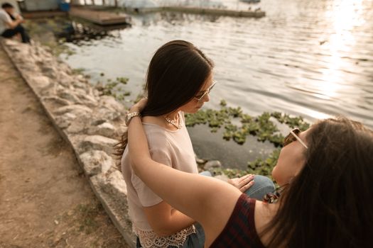 两个女人坐在湖边，给予情感支持和安慰