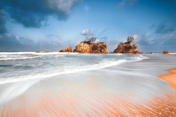 Waves Washing Shore Against Crags In Sea