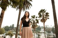 Woman in Black and Pink Dress Standing Beside Palm Tree