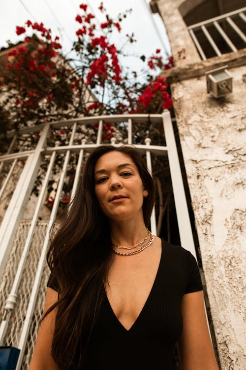 Low Angle Shot of a Woman Posing by a Gate