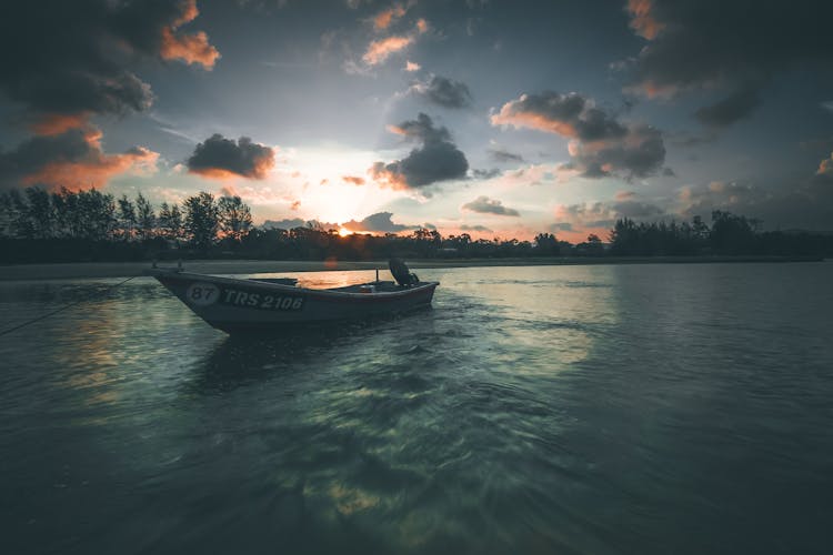 Boat Floating In Rippling Water Of River