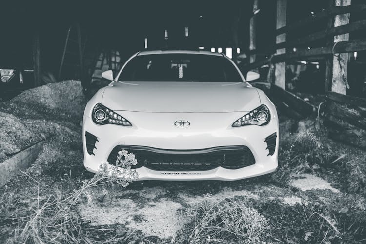 Modern Car Parked In Barn With Hay