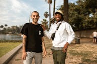 两个朋友在棕榈环绕的户外欢笑，尽显友谊与乐趣