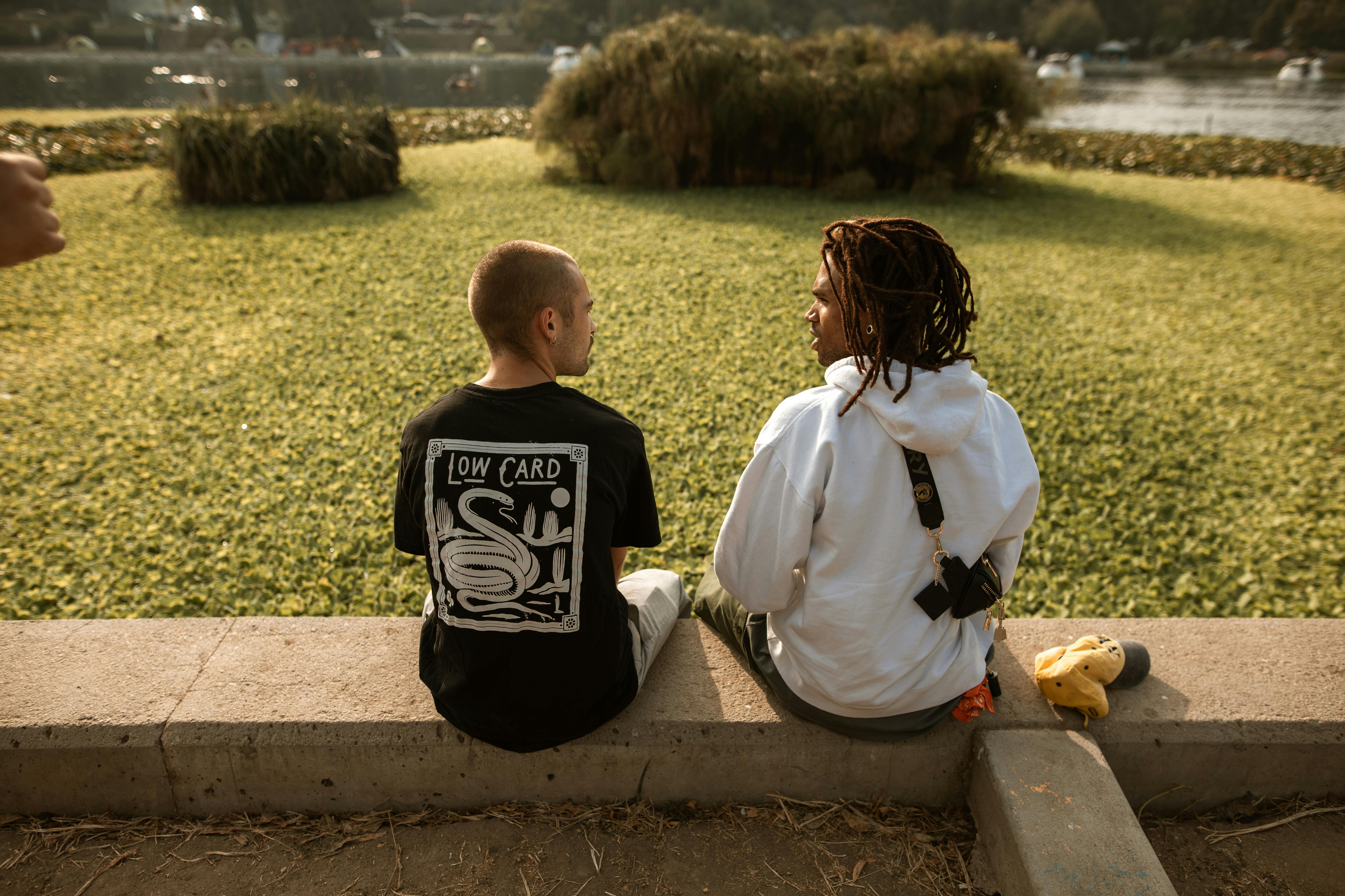 2 boys in black and white long sleeve shirt sitting on brown concrete bench