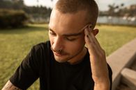 一名年轻人在公园里坐着时，感到压力和焦虑