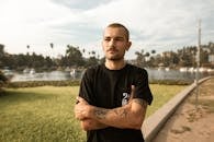 Man in Black Crew Neck T-shirt Standing on Green Grass Field