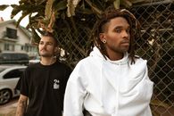 Man in White Nike Hoodie Standing Beside Man in Black Crew Neck Shirt