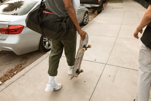 Man Walking with Bag and Skateboard