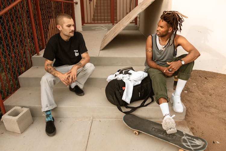 Two Men Talking And Sitting On Stairs