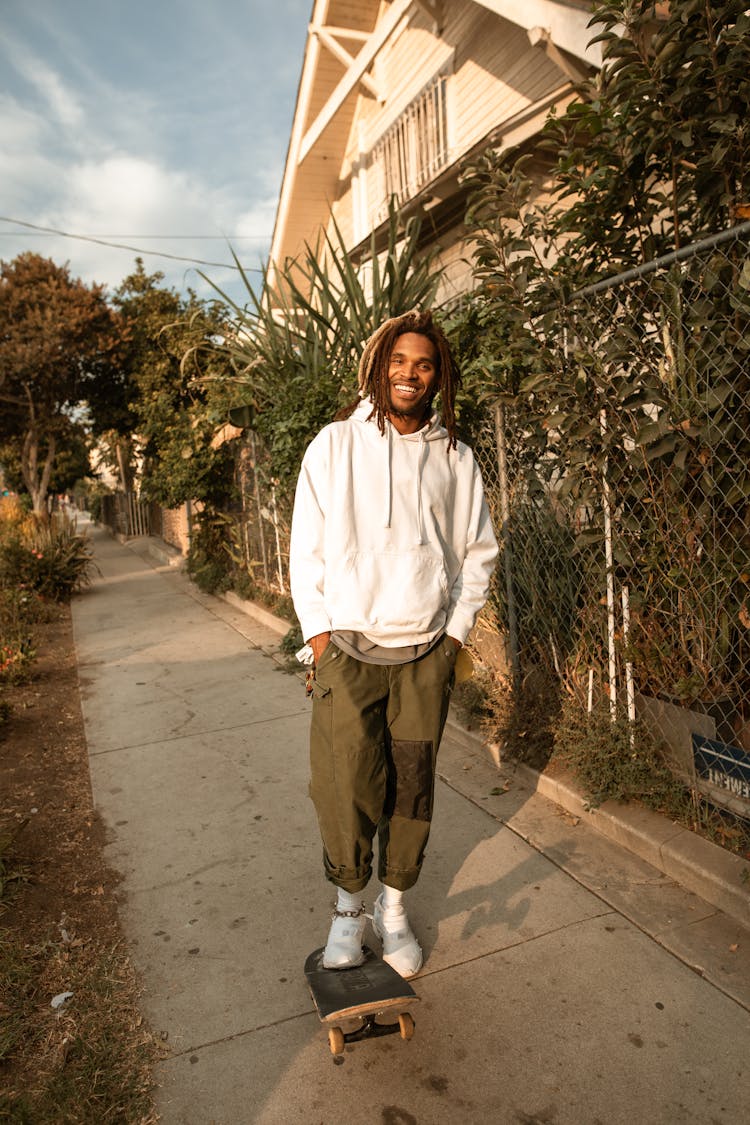 Man In White Hoodie Stepping On Skateboard