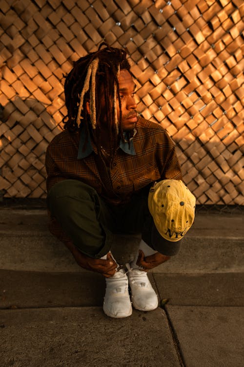 A Young Man Sitting on a Sidewalk