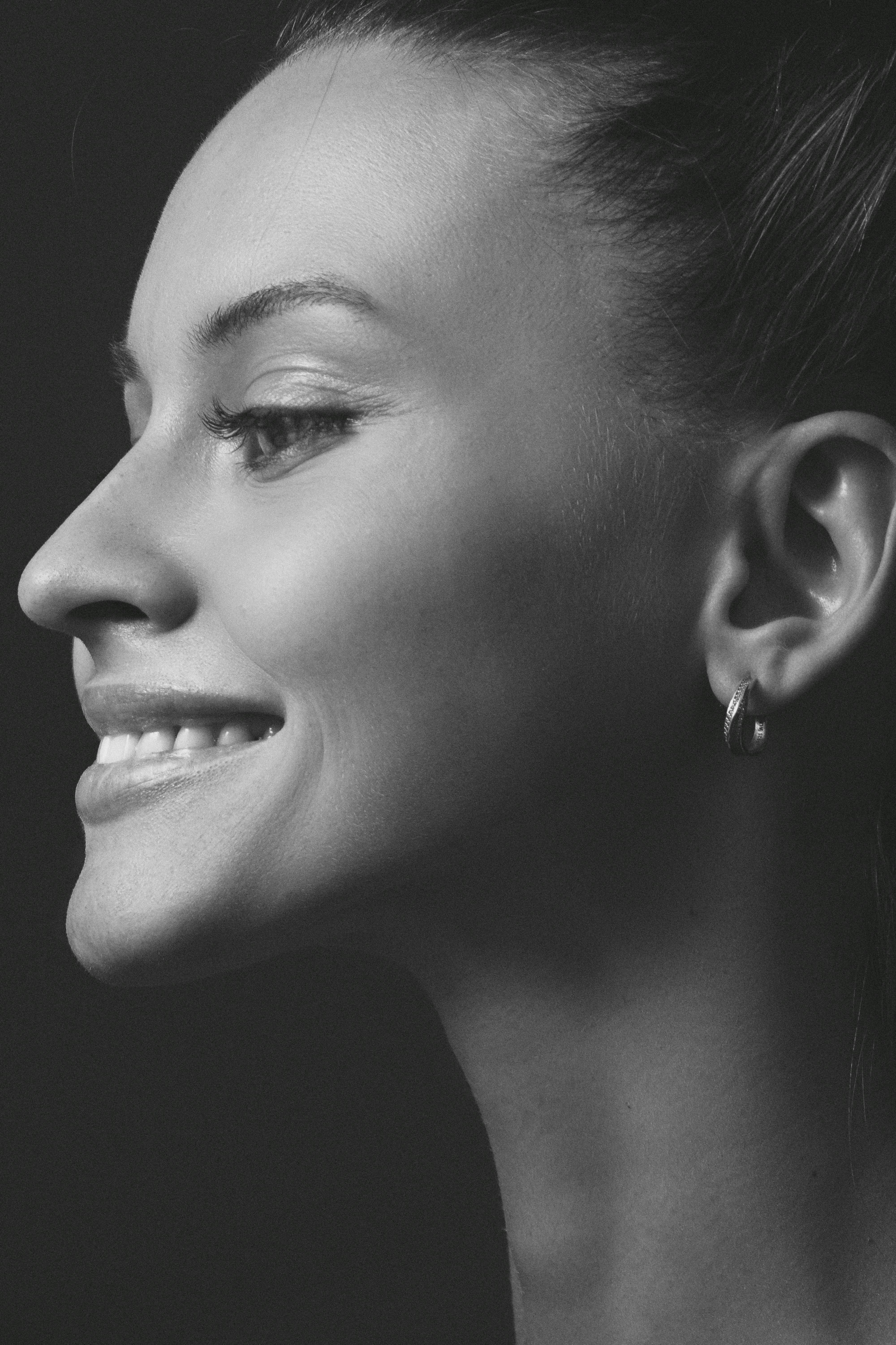 Side profile black and white portrait of a smiling woman in Kyiv.