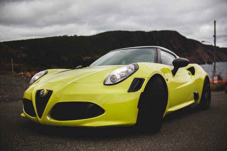 Luxury Sports Car Behind Mount Silhouette In Overcast Weather