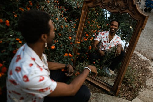 Улыбающийся человек, смотрящий на себя в зеркало