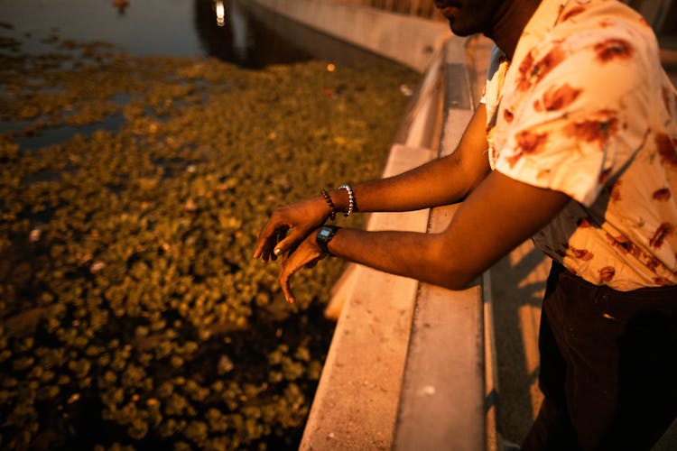 A Person In Floral Polo Leaning On A Railing