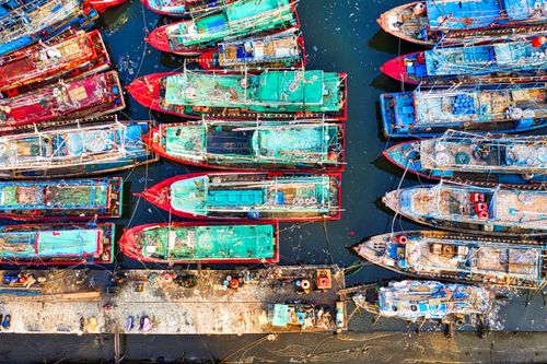 Free Vibrant fishing boats docked at a bustling harbor in Jakarta, Indonesia. Stock Photo