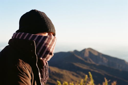 Traveler in warm clothes high in mountains