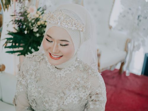 Free Smiling bride in intricate lace gown with floral tiara and hijab, embodying grace. Stock Photo