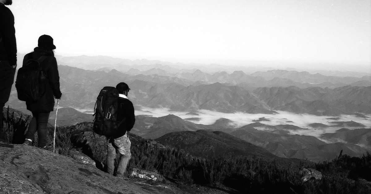 Hikers standing at the summit of Mount Afadja with a misty valley stretching into the distance