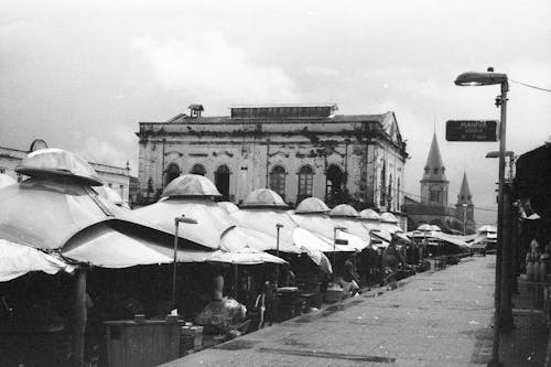 Black and white city market street with empty stalls against old weathered building