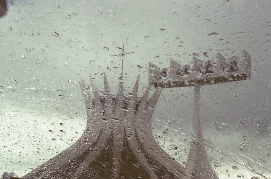 Silhouette of a cathedral seen through rain-speckled glass, creating an abstract view.