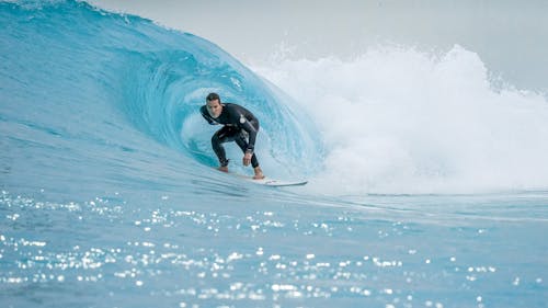 A Man in a Wetsuit Surfing a Wave