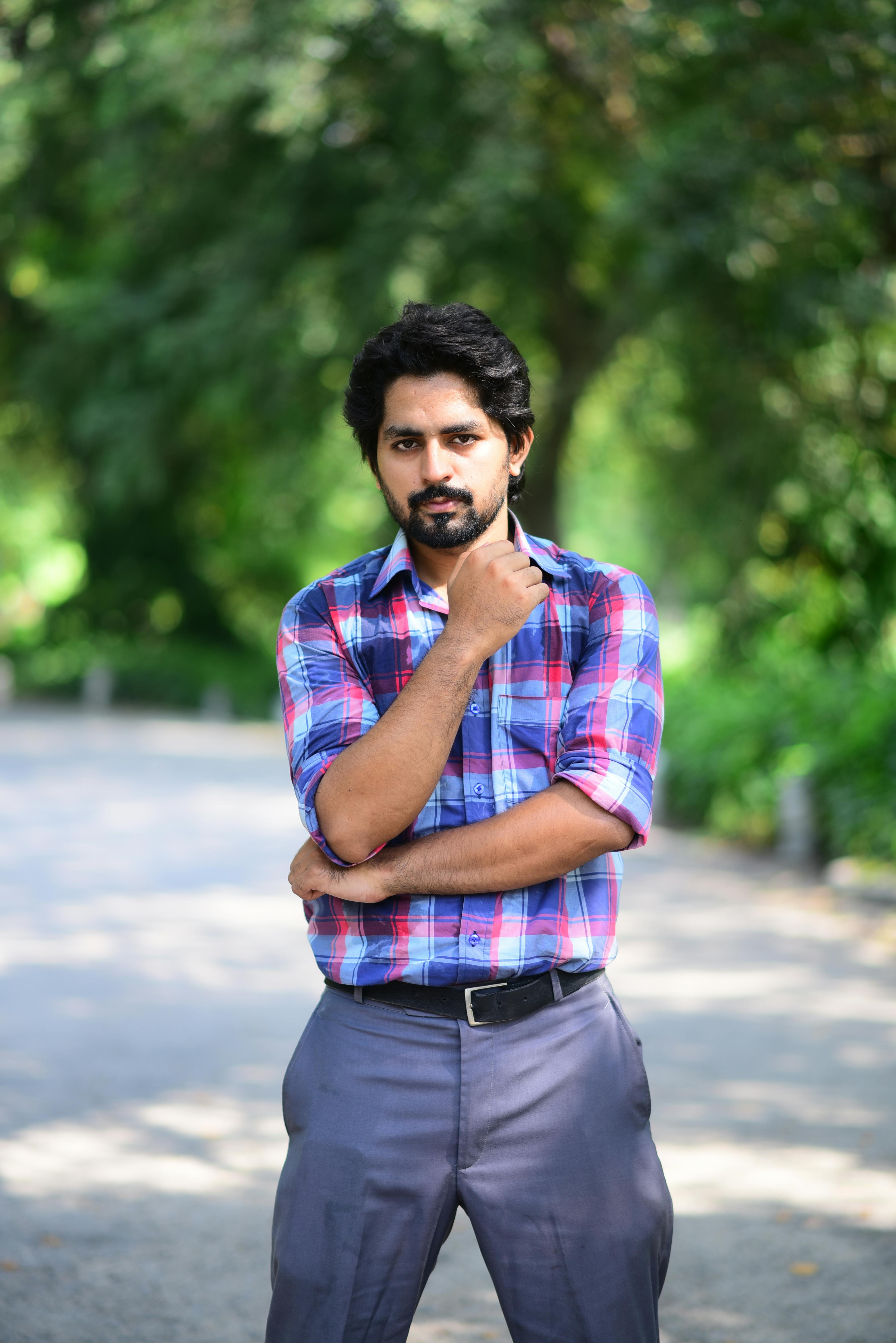 Man in Blue and White Plaid Shirt and Denim Jeans Standing on