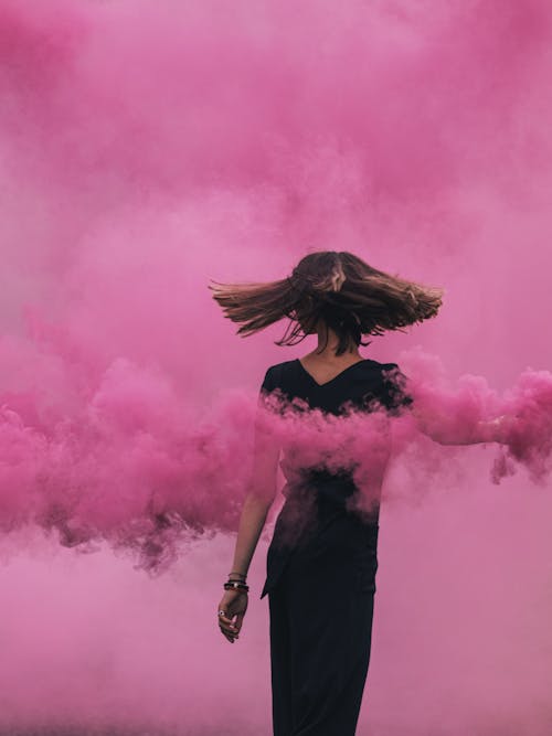 Person in Black Dress With Pink Smoke