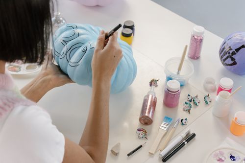 Free Creative art session with pumpkin painting for Halloween, emphasizing artistic expression and design. Stock Photo