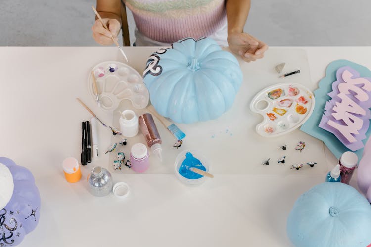 A Woman Painting A Pumpkin