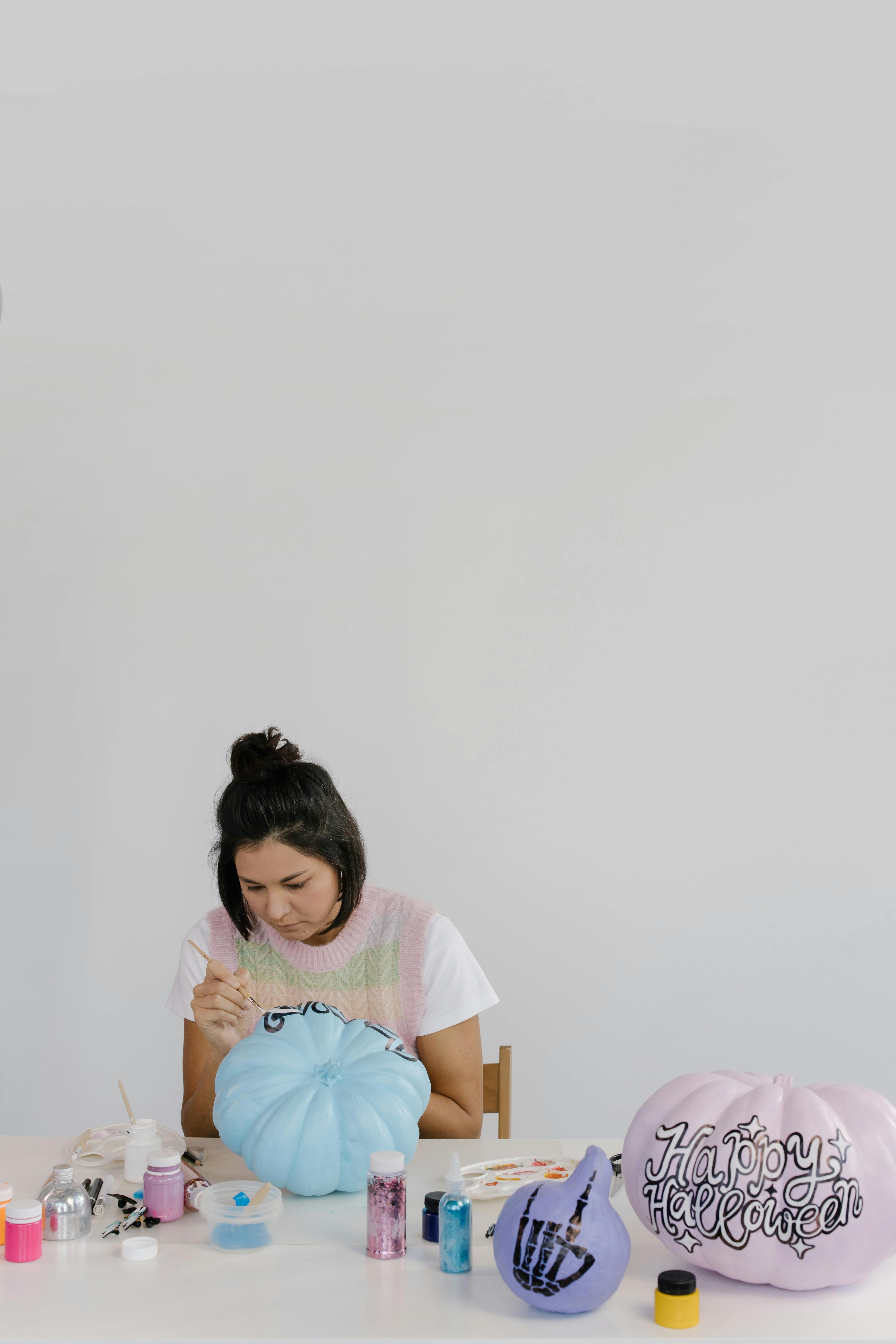 a woman painting a pumpkin