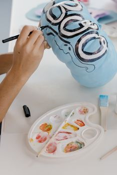 双手特写绘制万圣节南瓜的艺术用品
