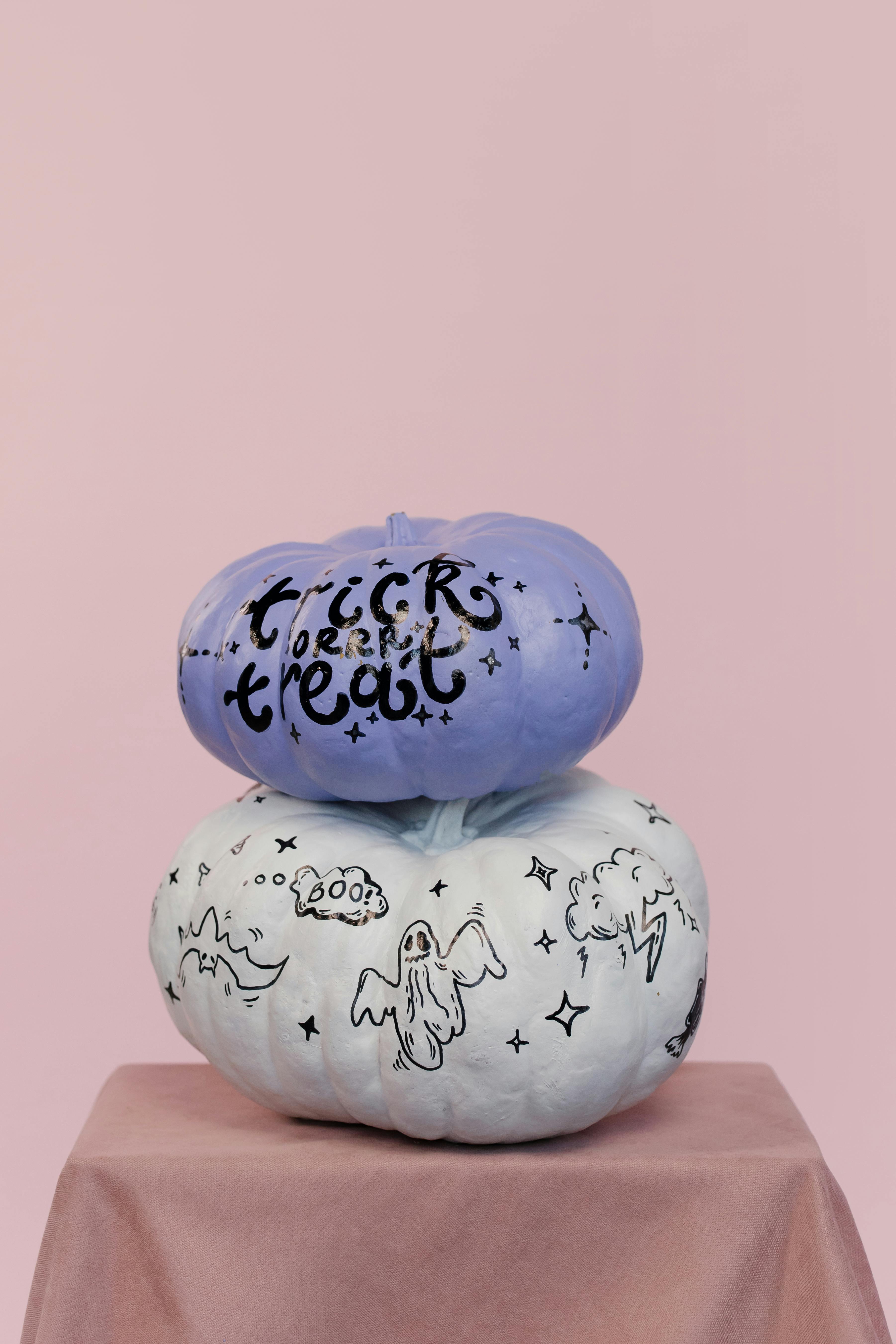 这两个装饰南瓜带有幽灵图案，非常适合万圣节装饰