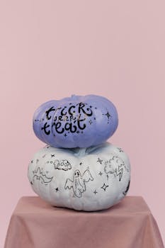 这两个装饰南瓜带有幽灵图案，非常适合万圣节装饰